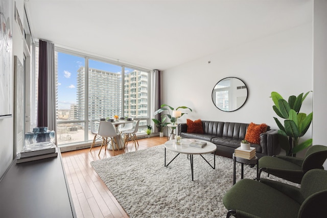 living area with expansive windows, wood finished floors, and a city view