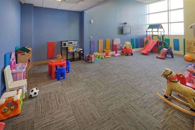 game room with a paneled ceiling, baseboards, and carpet