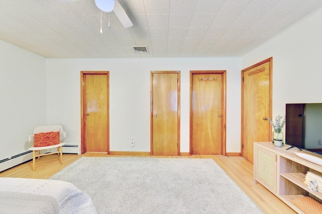 76 Central Ave, Secaucus, NJ 07094 - bedroom featuring light wood-style flooring, two closets, a baseboard heating unit, and a ceiling fan