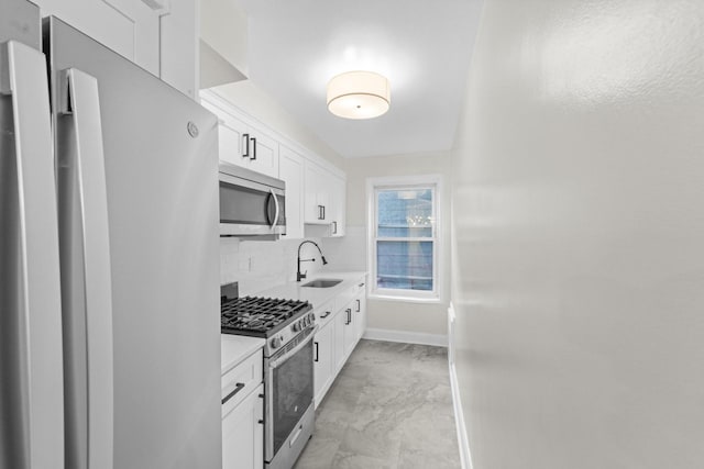 154 Bowers St Unit 2A, Jersey City, NJ 07307 - kitchen featuring appliances with stainless steel finishes, light countertops, decorative backsplash, white cabinetry, and light marble finish flooring