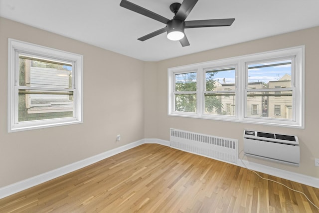 154 Bowers St Unit 2A, Jersey City, NJ 07307 - spare room featuring radiator, a wall unit AC, light wood-style floors, and ceiling fan