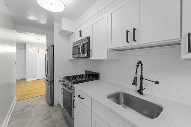 154 Bowers St Unit 2A, Jersey City, NJ 07307 - kitchen featuring appliances with stainless steel finishes, white cabinetry, backsplash, and light stone countertops