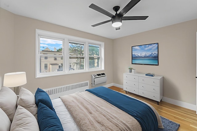154 Bowers St Unit 2A, Jersey City, NJ 07307 - bedroom with radiator, a wall mounted air conditioner, light wood-style flooring, and ceiling fan