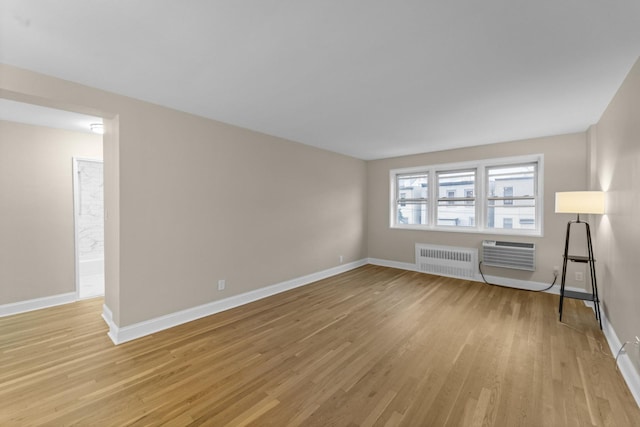 154 Bowers St Unit 2A, Jersey City, NJ 07307 - empty room with radiator, light wood-type flooring, and a wall mounted air conditioner