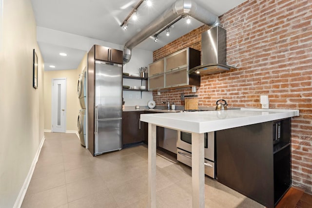 68 Park Ave Unit 3, Hoboken, NJ 07030 - kitchen with estacked washer and dryer, wall chimney exhaust hood, stainless steel appliances, open shelves, and light countertops