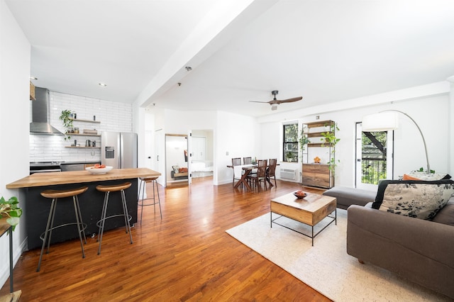 living area featuring baseboards, a ceiling fan, and wood finished floors