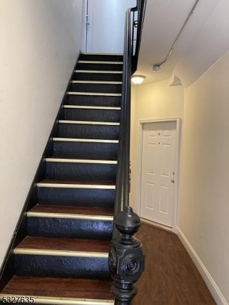 stairs featuring hardwood / wood-style floors