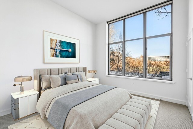 bedroom with light colored carpet and baseboards