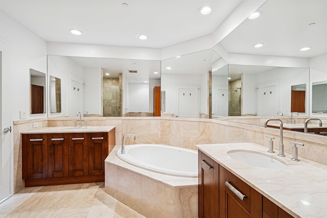 full bath featuring a shower stall, a garden tub, and a sink