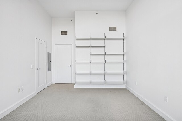 unfurnished room featuring visible vents, baseboards, carpet flooring, and electric panel