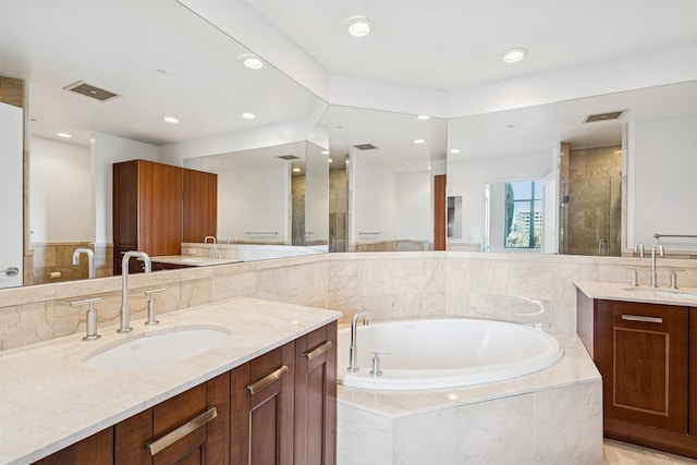 bathroom with a sink, two vanities, a stall shower, and a bath