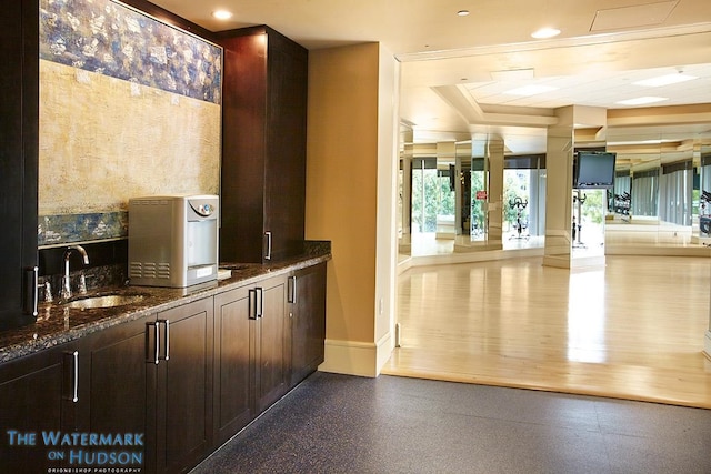bar featuring recessed lighting, baseboards, and a sink
