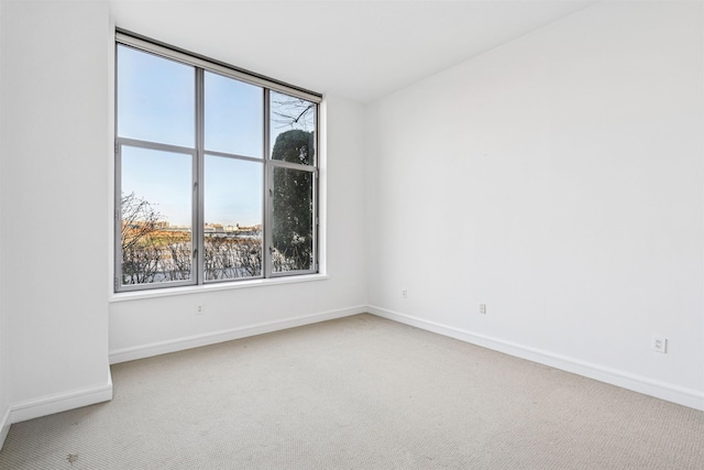 spare room featuring carpet floors and baseboards