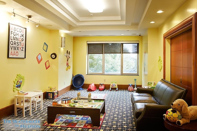 recreation room with a tray ceiling, baseboards, and recessed lighting