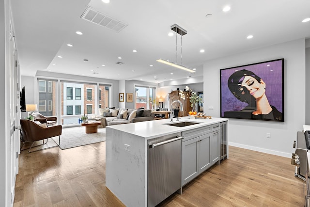 kitchen with a sink, wine cooler, gray cabinets, visible vents, and stainless steel dishwasher