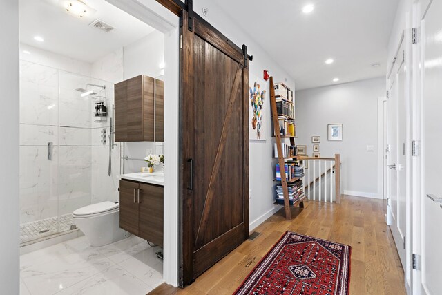 interior space with a barn door, an upstairs landing, visible vents, and recessed lighting