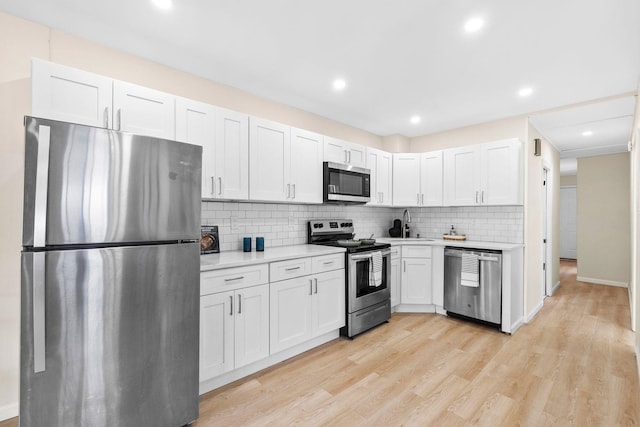 80 E 24th St, Bayonne, NJ 07002 - kitchen featuring appliances with stainless steel finishes, light countertops, decorative backsplash, light wood finished floors, and recessed lighting
