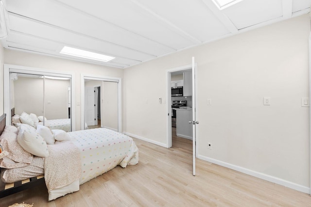 80 E 24th St, Bayonne, NJ 07002 - bedroom with light wood-type flooring, baseboards, and two closets