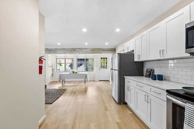 80 E 24th St, Bayonne, NJ 07002 - kitchen with light countertops, light wood-style flooring, white cabinetry, baseboards, and recessed lighting
