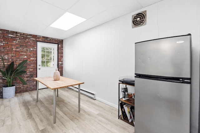 80 E 24th St, Bayonne, NJ 07002 - home office featuring a baseboard radiator, light wood finished floors, a paneled ceiling, baseboards, and brick wall