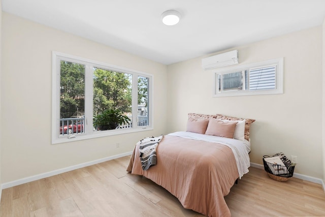 80 E 24th St, Bayonne, NJ 07002 - bedroom with a wall unit AC, light wood-style flooring, and baseboards