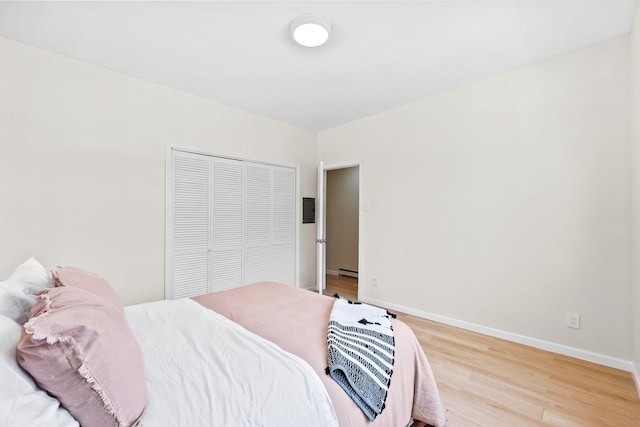 80 E 24th St, Bayonne, NJ 07002 - bedroom with light wood-style floors, a baseboard radiator, baseboards, and a closet