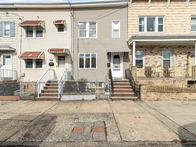 multi unit property with brick siding, fence, and a gate