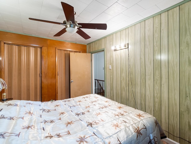 bedroom with ceiling fan and multiple closets