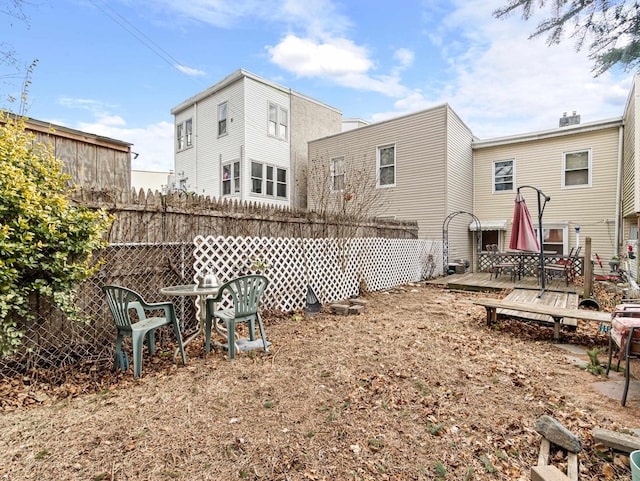 back of house featuring a deck and fence