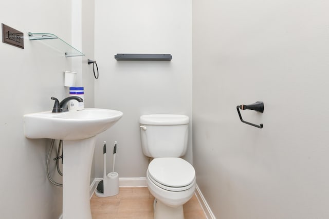 bathroom with toilet and baseboards