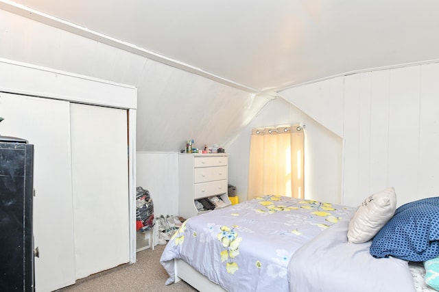 bedroom featuring a closet, carpet flooring, and vaulted ceiling