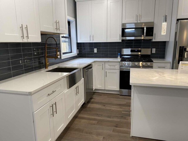 41 Beacon Ave Unit 1, Jersey City, NJ 07306 - kitchen featuring appliances with stainless steel finishes, a sink, dark wood finished floors, white cabinets, and light stone countertops