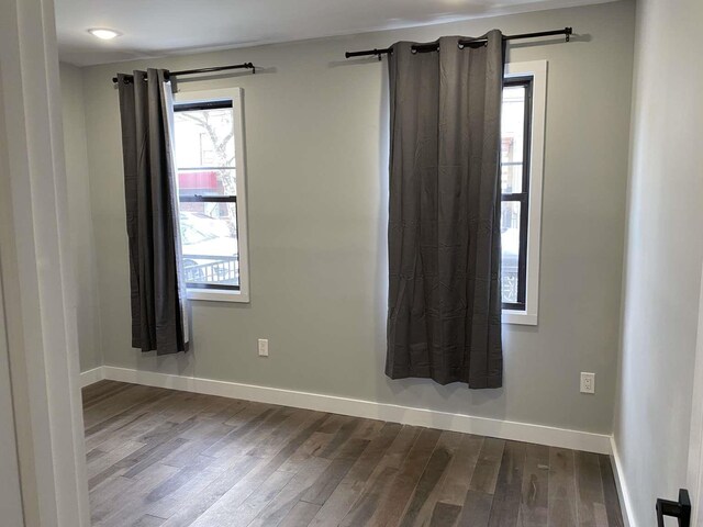 41 Beacon Ave Unit 1, Jersey City, NJ 07306 - empty room with dark wood-style flooring, baseboards, and healthy amount of natural light