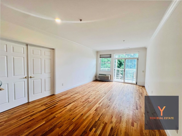 1100 River Rd, Edgewater, NJ 07020 - unfurnished living room with ornamental molding, wood finished floors, and an AC wall unit