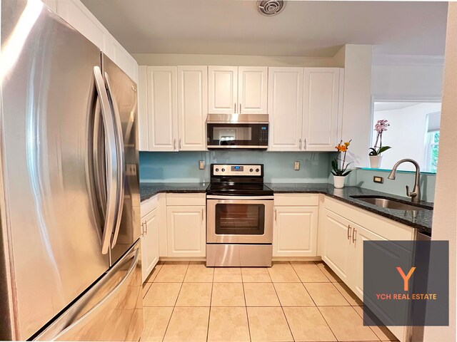 1100 River Rd, Edgewater, NJ 07020 - kitchen with stainless steel appliances, light tile patterned floors, and white cabinets