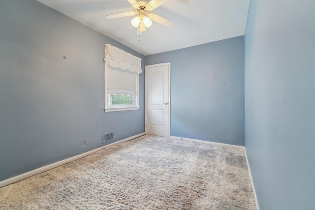 unfurnished room with carpet, visible vents, and a ceiling fan