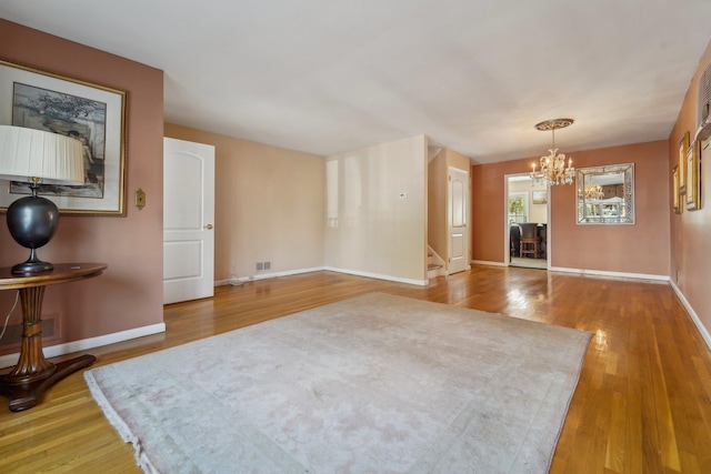 170 W 8th St, Bayonne, NJ 07002 - unfurnished living room featuring wood finished floors, a chandelier, stairs, and baseboards