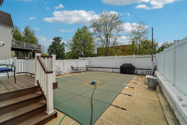 view of swimming pool with a patio area, a wooden deck, grilling area, and a fenced backyard
