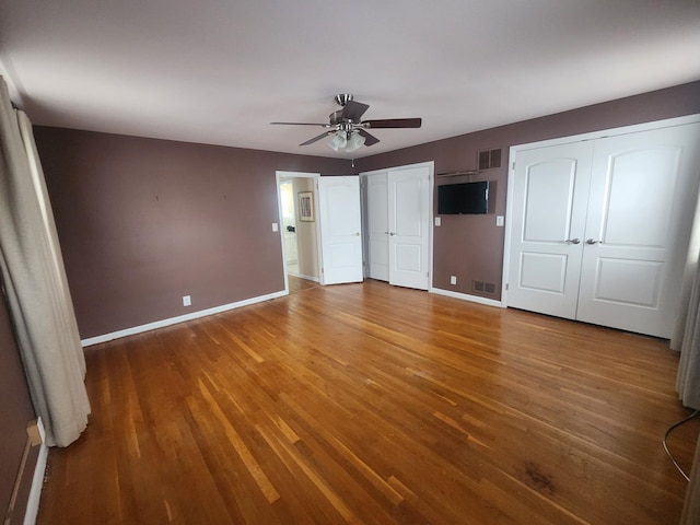 170 W 8th St, Bayonne, NJ 07002 - unfurnished bedroom featuring two closets, wood finished floors, and baseboards