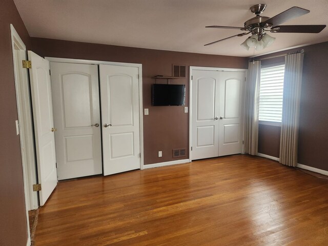 170 W 8th St, Bayonne, NJ 07002 - unfurnished bedroom featuring two closets, baseboards, light wood finished floors, and ceiling fan