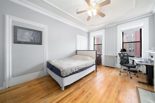 bedroom with ceiling fan, radiator, crown molding, and light hardwood / wood-style floors