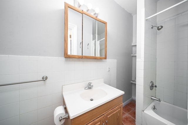 bathroom featuring tile patterned floors, tile walls, vanity, and tiled shower / bath