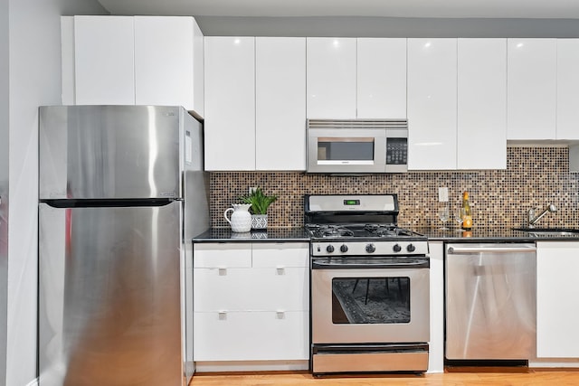 29 51st St Unit A2, Weehawken, NJ 07086 - kitchen with stainless steel appliances, dark countertops, a sink, and white cabinetry