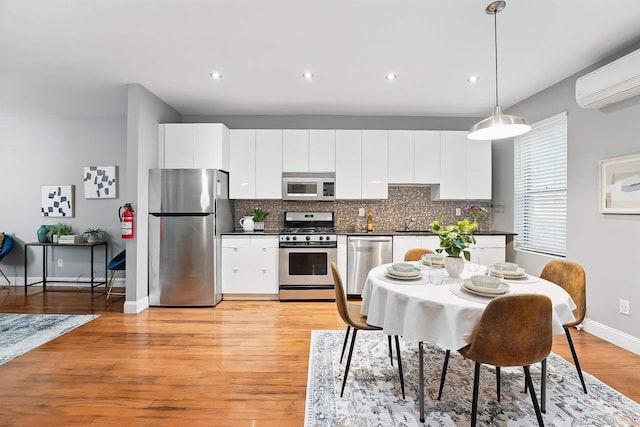 29 51st St Unit A2, Weehawken, NJ 07086 - kitchen with stainless steel appliances, dark countertops, white cabinets, decorative backsplash, and a sink