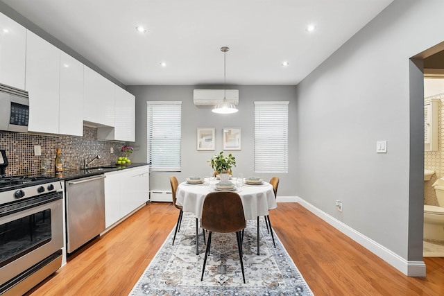 29 51st St Unit A2, Weehawken, NJ 07086 - kitchen featuring stainless steel appliances, a wall mounted air conditioner, baseboards, a sink, and tasteful backsplash