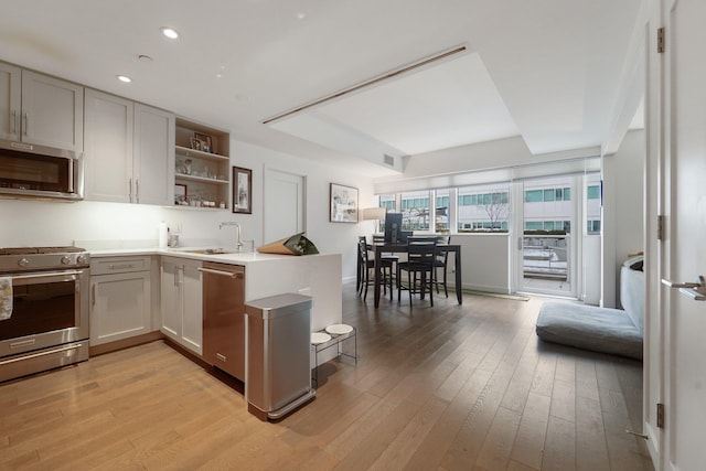 800 Ave At Port Imperial Unit 308, Weehawken, NJ 07086 - kitchen with open shelves, light wood finished floors, stainless steel appliances, and a sink