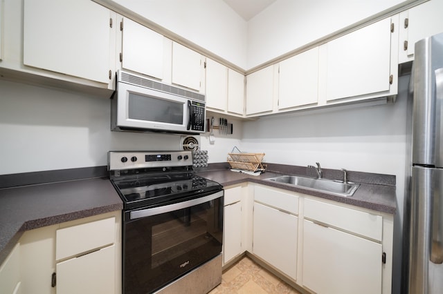 230 Bloomfield St Unit 302, Hoboken, NJ 07030 - kitchen featuring stainless steel appliances, a sink, dark countertops, and white cabinets