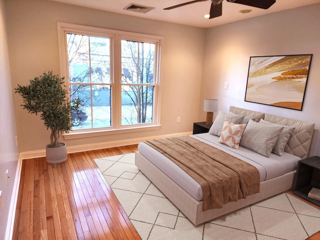 bedroom featuring light wood-type flooring, baseboards, visible vents, and ceiling fan