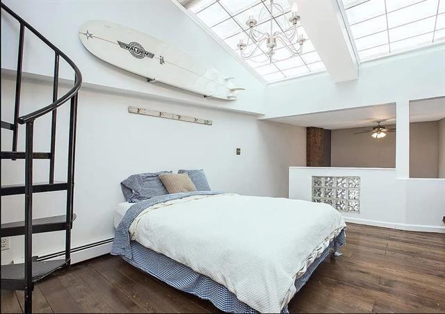 bedroom with dark wood-type flooring, baseboard heating, and an inviting chandelier