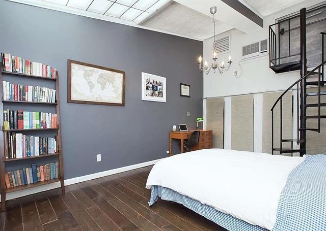 bedroom featuring an inviting chandelier, dark hardwood / wood-style floors, a wall mounted AC, and beamed ceiling